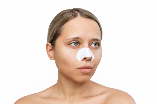 年轻的白人金发女人用清洁黑头鼻带，皮肤上有黑点图片下载