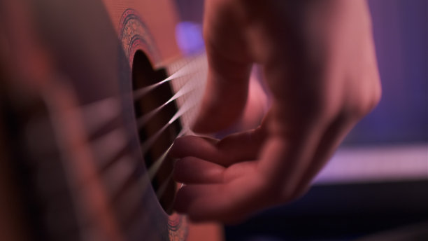 一个男人弹吉他的手特写。图片下载