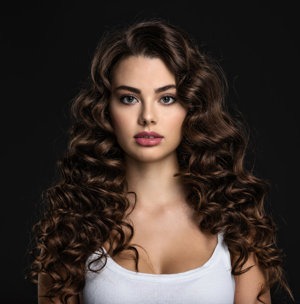 长着棕色卷发的美丽年轻女子图片下载