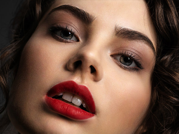 一个漂亮的女人的脸，烟熏妆和红色的口红图片下载