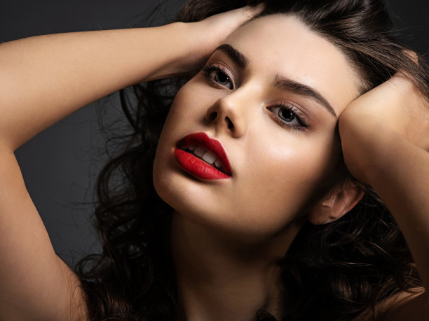 一个漂亮的女人的脸，烟熏妆和红色的口红图片下载