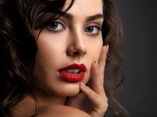 一个漂亮的女人的脸，烟熏妆和红色的口红图片下载