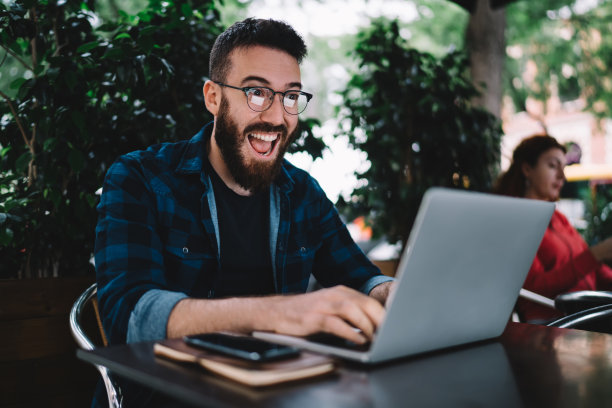 男子在笔记本电脑上阅读振奋人心的新闻图片下载