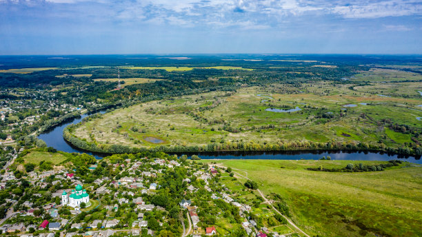 鸟瞰一个美丽夏日的小城市，背后是一片绿色的风景。这张照片来自一个阳光明媚的日子里的村子。俯瞰夏季乡村景观。图片下载