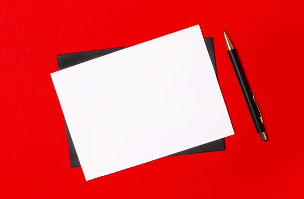 黑色的钢笔，信封和白色的空白卡片与空间插入文本在鲜红色的背景图片下载