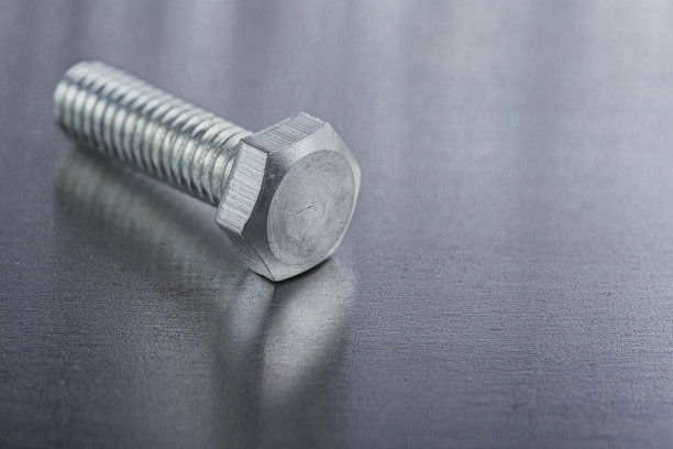 在钢板背景上设置不同的螺母，螺栓，螺钉，垫圈和钻头，丝锥和铣刀。锁匠工作协议。图片下载