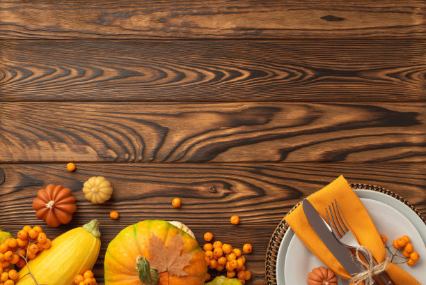 感恩节的概念。俯视照片的盘子刀叉餐巾生蔬菜南瓜西葫芦rowan浆果和枫叶在孤立的深色木桌背景与copyspace图片下载