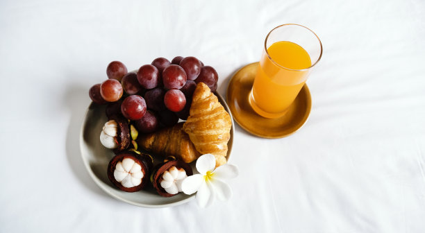 早餐，水果，羊角面包，白床单上的橙汁，健康食品的概念图片下载