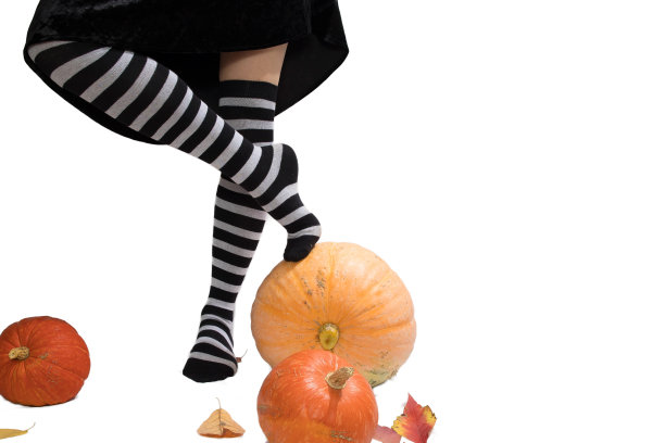 细长的女性腿穿着条纹长袜，白色背景上有南瓜，是邀请函或明信片的空白图片下载