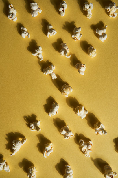 黄色背景的爆米花。副本的空间。流行玉米集合。不同大小的爆米花排在一个生的图片下载