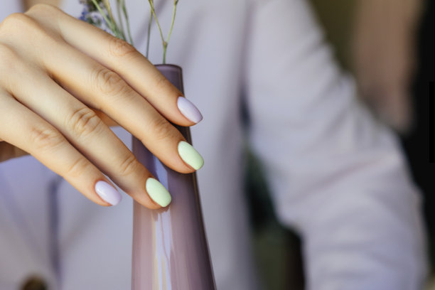 美丽的紫色美甲在乳白色的背景。图片下载