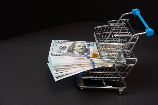购物车里有钱，黑色背景的百元钞票，购买的概念，花钱，黑色星期五的销售，货币图片下载