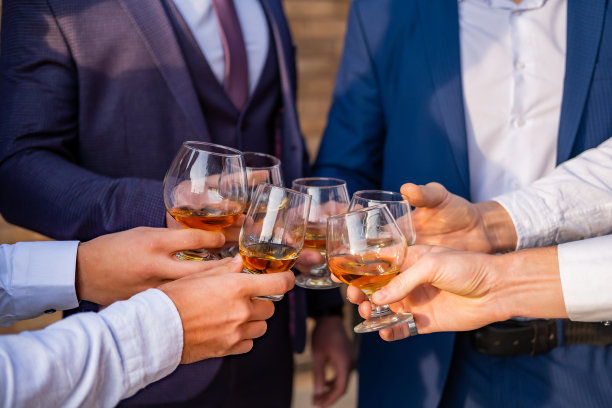 度假的年轻人拿着威士忌杯。手戴眼镜特写图片下载