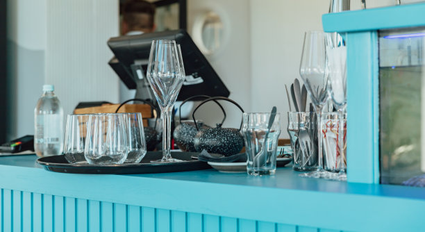 餐馆或咖啡馆吧台上各种形状的空玻璃杯和小茶壶。咖啡厅的现代内饰细节。健美的形象。图片下载