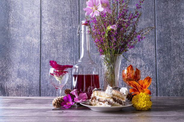 复古静物与一束夏天的野花，红葡萄酒的醒酒器，酒杯和蛋糕片木桌。图片下载