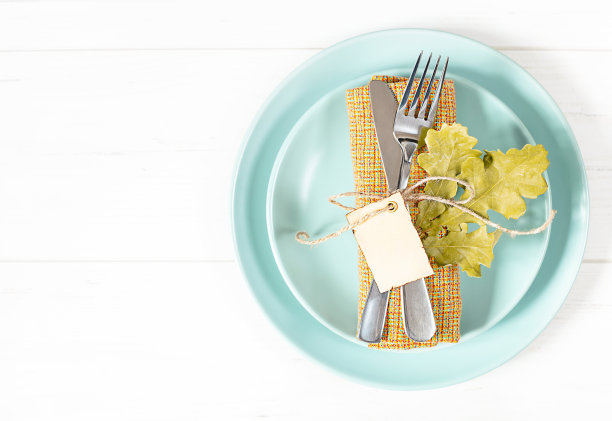 白色的桌子上有餐具和餐巾的盘子素材图片