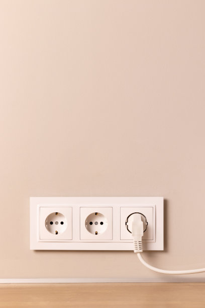 插座与插头在米色墙壁上图片下载
