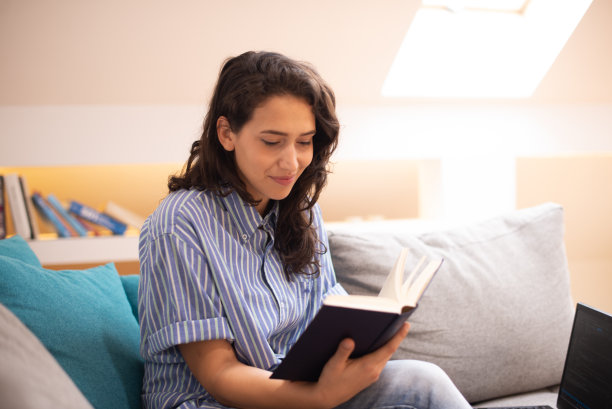 快乐的女人在家看书库存照片图片下载