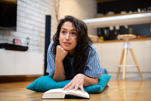 快乐的女人在家看书库存照片图片下载