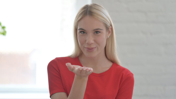 年轻的金发女人给飞吻的手肖像图片下载