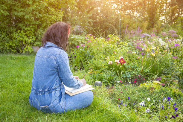 一名妇女在户外的速写本上画花图片下载