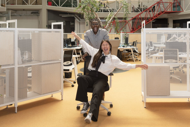 多民族的商务同事在工作休息时间坐在办公室轮椅上，在一个联合办公空间里玩得很开心图片下载