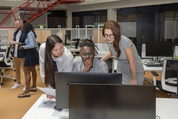 三个多民族的商业伙伴在一个联合办公空间的电脑上做一个项目图片下载