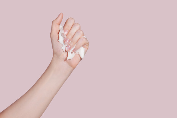 女性手，粉色背景磨砂。皮肤护理的概念。图片下载