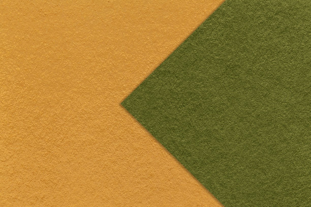 质感的黄色纸张背景，半两色带有深绿色箭头，微距。工艺橄榄纸板。图片下载