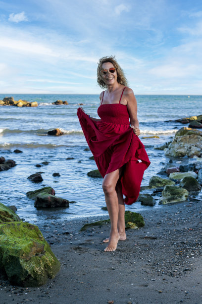 海滩上有个50多岁穿红衣服的女人图片下载