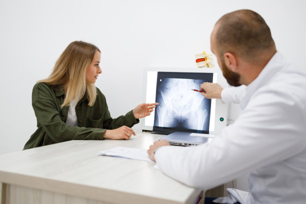 整形外科医生或创伤科医生向女性患者展示x线图像。一名妇女正在咨询医生图片下载
