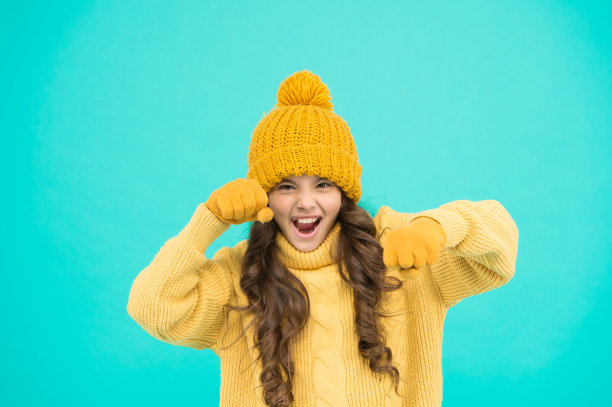 儿童冬季活动。小女孩俏皮的心情蓝绿色背景。小孩子准备玩了。时尚和美丽。保暖的针织衣服和配饰。感觉自己充满力量和活力图片下载