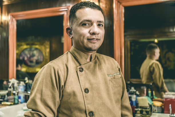 戴着助听器的聋哑年轻理发师看着镜头。图片下载