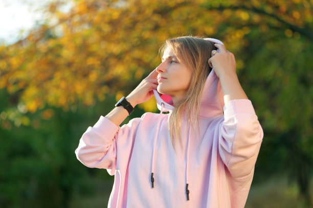 美丽的金发女人摘下兜帽图片下载