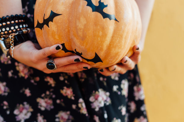 特写的女孩持有蝙蝠概念万圣节南瓜图片下载