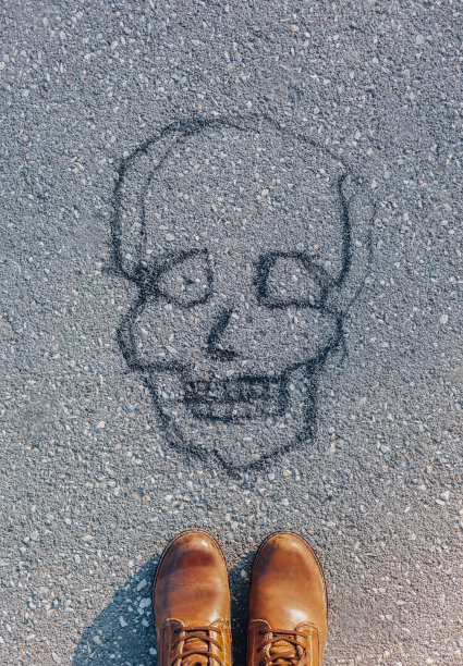柏油路上画着骷髅头和脚图片下载