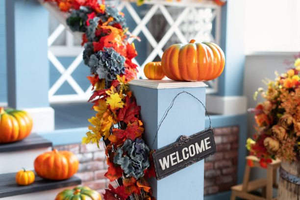 为万圣节装饰的住宅。木制台阶上前门不同颜色的南瓜。秋天，院子的门廊上装饰着橙色的南瓜。感恩节。万圣节在外面。图片下载