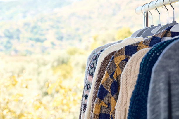 针织毛衣挂在衣架的衣架上。慢时尚。有意识的消费。车库甩卖，再利用衣物，二手和生态消费理念。图片下载