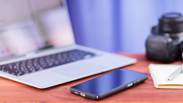 视频博客。笔记本电脑，智能手机，笔记本电脑和相机放在一张木桌上。自由职业和视频博客的概念图片下载