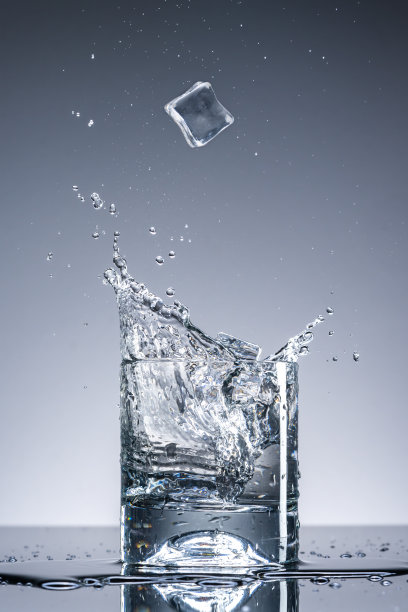 一杯加冰块的水。水溅图片下载