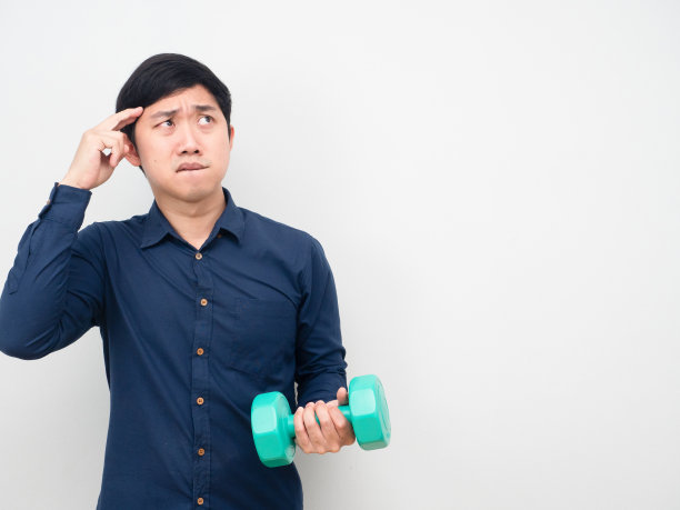 男人抱着哑铃，想着食物，懒懒地琢磨着概念图片下载