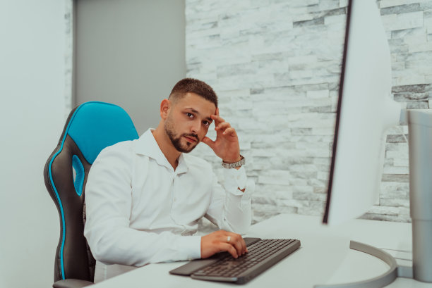 一个人在办公室的电脑前工作。高质量的照片图片下载