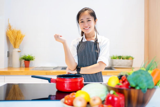 年轻的亚洲女人在厨房做饭图片下载