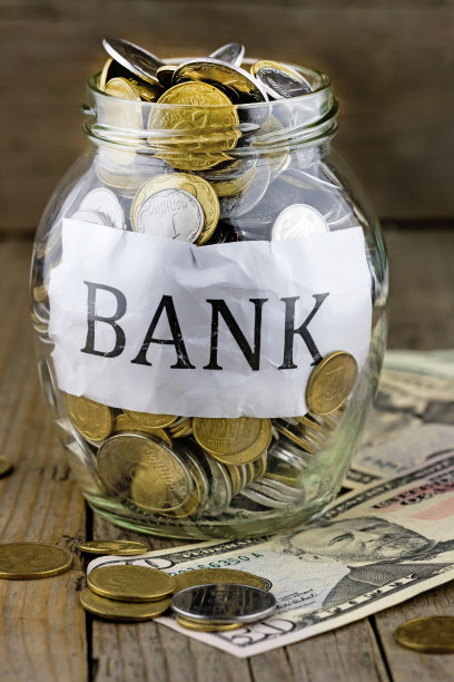 装满硬币和美元钞票的储蓄罐图片下载