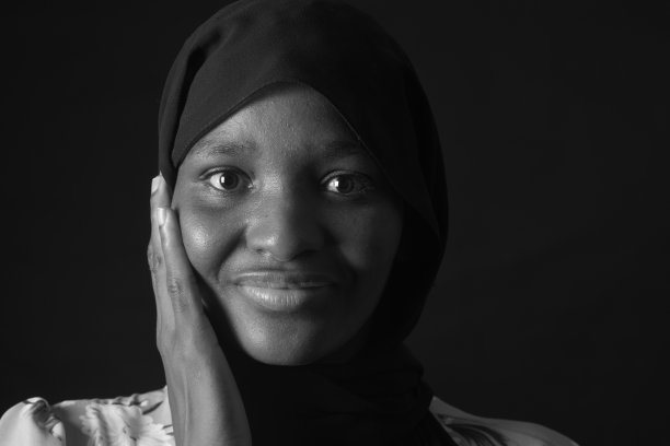 黑色和白色的黑色肖像，一个女人与burka和手在脸上图片下载