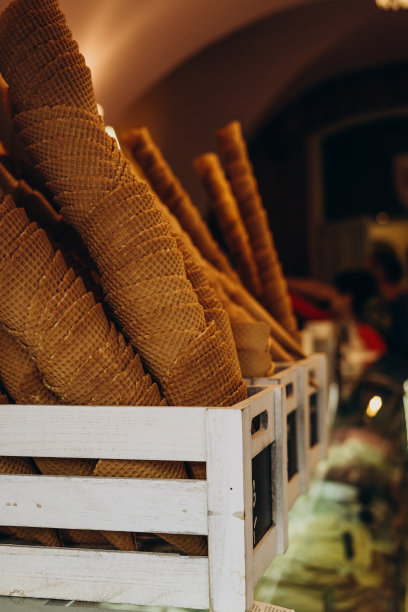 盒装冰淇淋的锥形华夫饼杯。装在木箱里的甜糖华夫饼杯。冰淇淋店里的脆华夫饼杯。图片下载