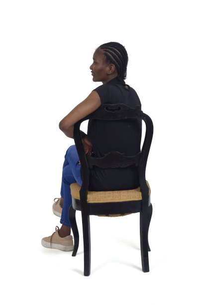 一个女人的肖像从后面坐在椅子上看在白色的背景图片下载