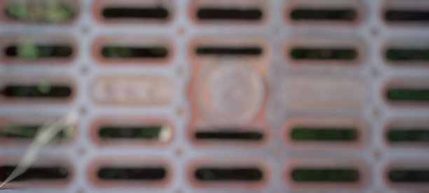 离焦抽象背景的老金属街道水下水道盖图片下载