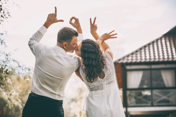 美丽幸福的情侣在爱的男人和女人用他们的背，手的形式题写爱，肖像在大自然图片下载