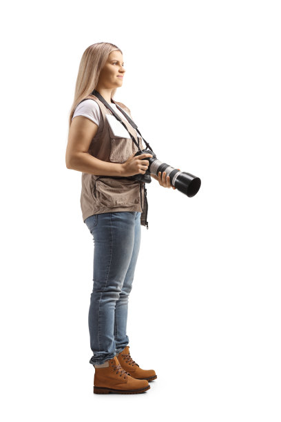 一个年轻的女摄影师拿着相机的完整长度的侧面镜头图片下载
